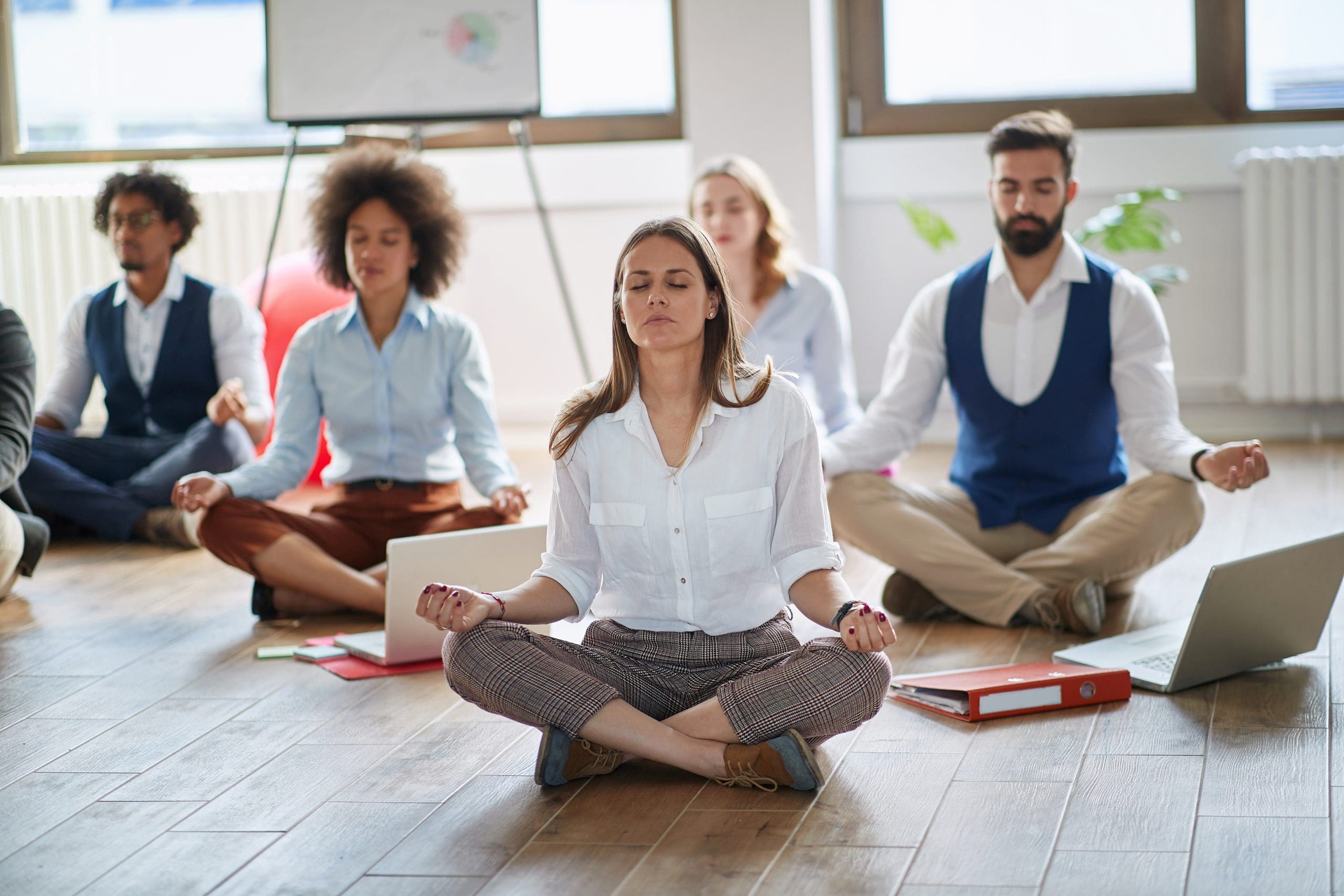 Businesswoman meditating at work.group of business coworkers meditating together.